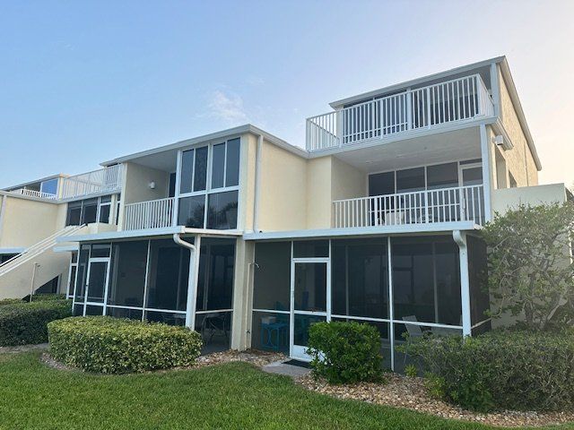 A large house with a screened in porch and a balcony.