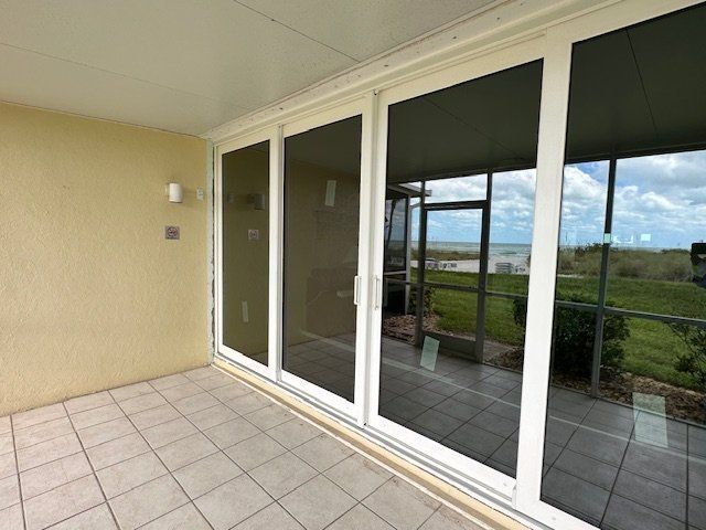 A patio with sliding glass doors and a view of the ocean
