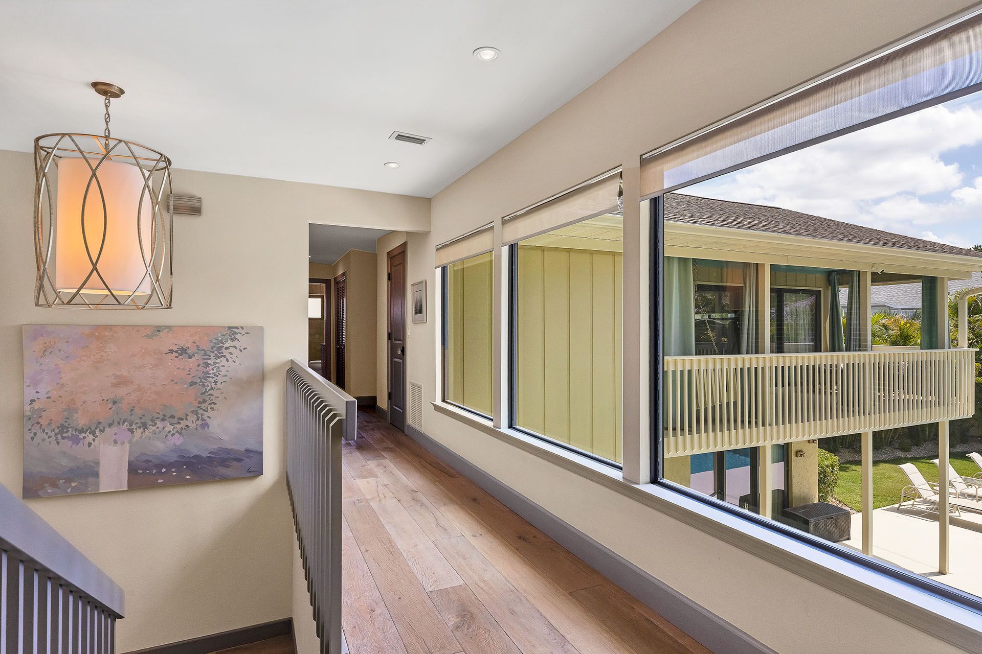 A hallway with a lot of windows and a painting on the wall.