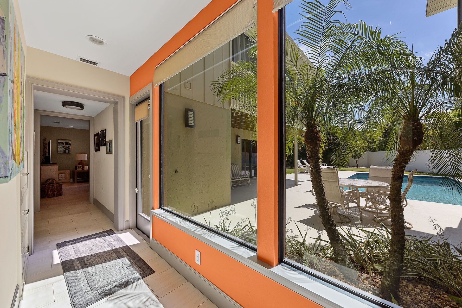A hallway with a large window and a pool in the background