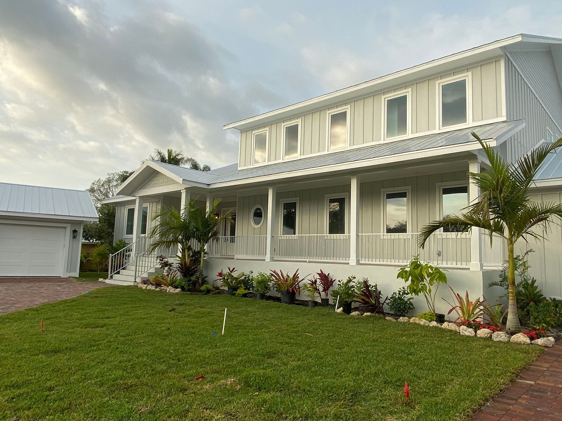 A large white house with a large porch and a garage