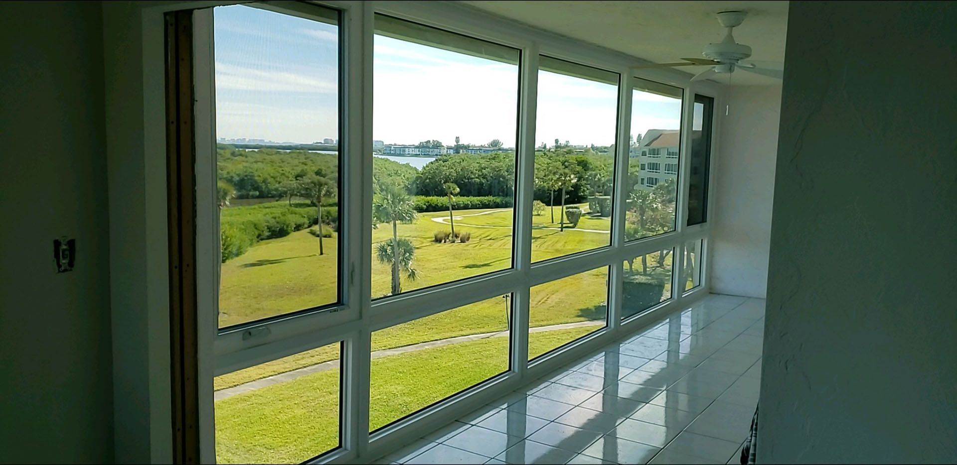 A room with a lot of windows and a view of a field.