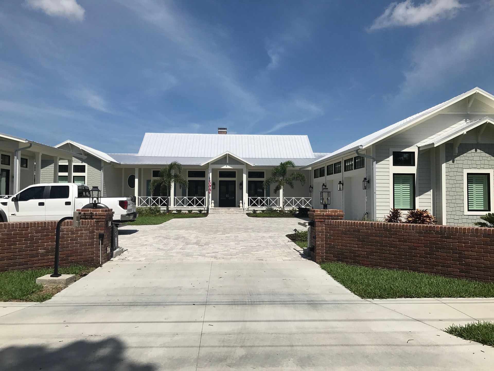 A large white house with a white truck parked in front of it.
