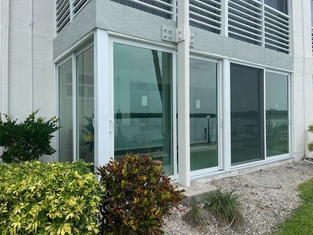 A house with a lot of windows and a bush in front of it.