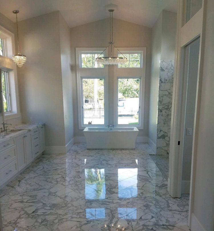 A bathroom with marble floors and a bathtub