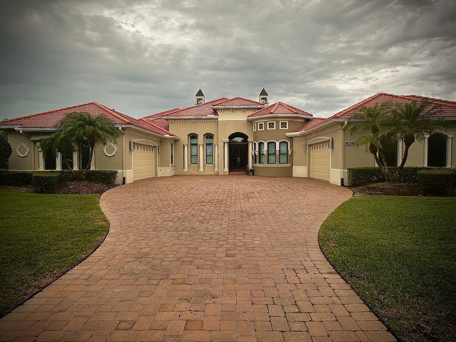 A large house with a brick driveway leading to it