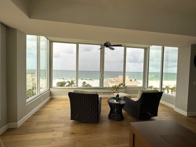 A living room with two chairs and a table with a view of the ocean