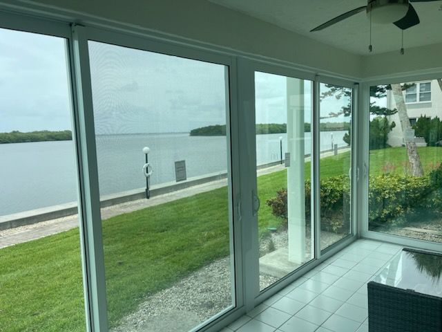 A screened in porch with a view of a body of water.