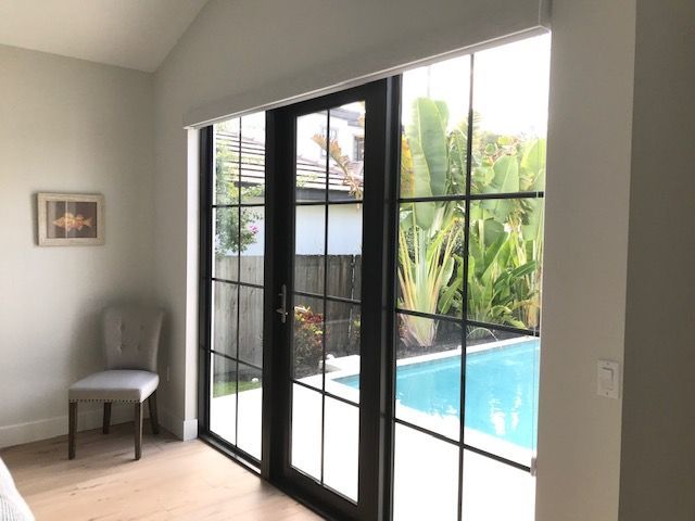 A bedroom with sliding glass doors leading to a pool.
