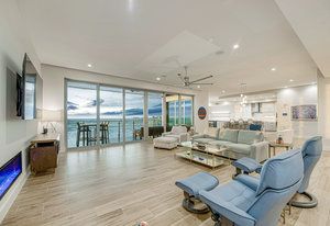 A living room with a couch, chair, fireplace, and television.