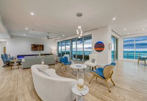 A living room filled with furniture and a view of the ocean.