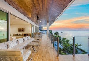 There is a large balcony with a view of the ocean.