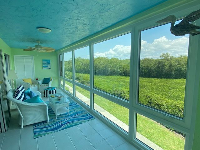 A living room with a lot of windows and a blue ceiling
