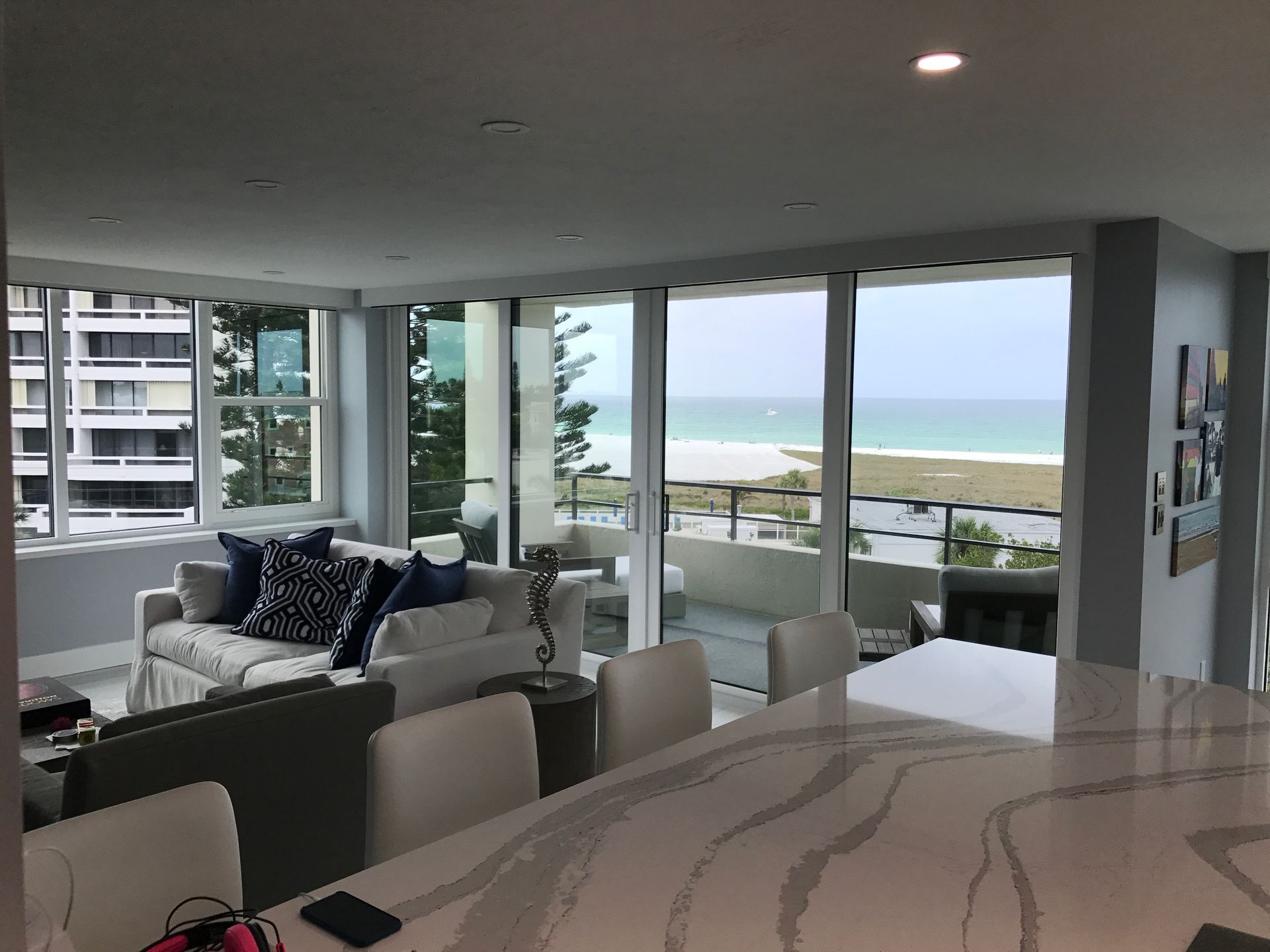 A living room with a couch and a table with a view of the ocean