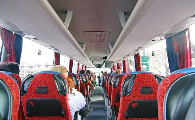 The inside of a bus with red and black seats