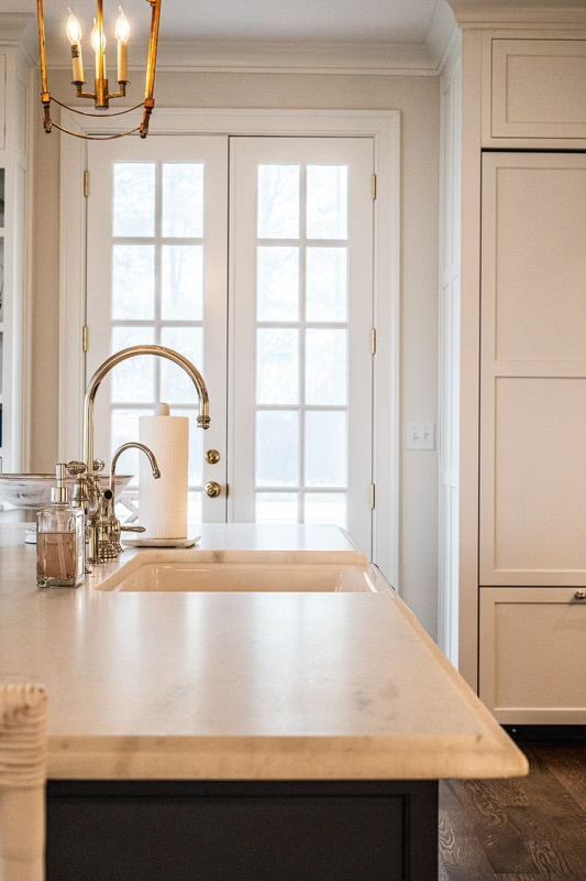 A kitchen with a sink, refrigerator, and french doors.