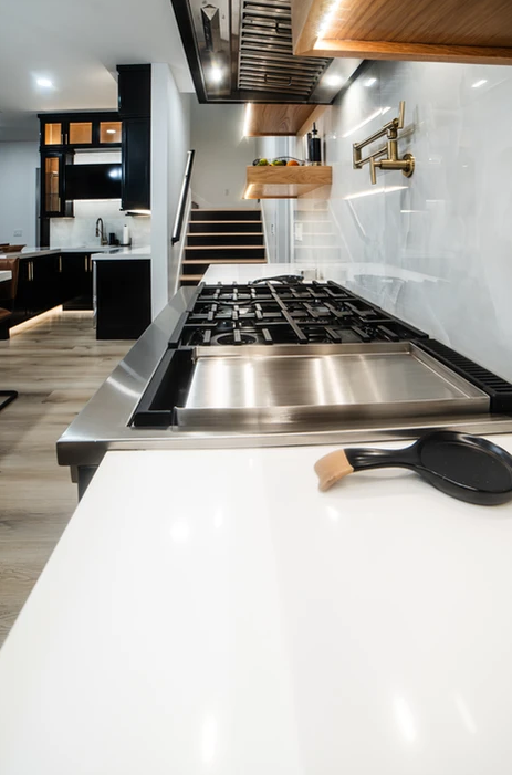 A stove top oven is sitting on top of a white counter in a kitchen.