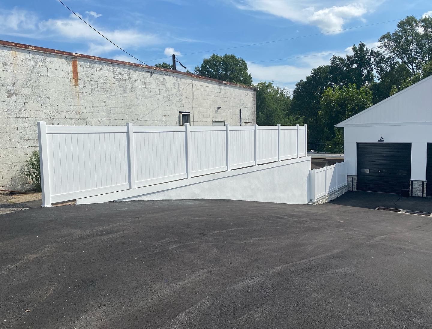 A white fence with a ramp leading to a garage