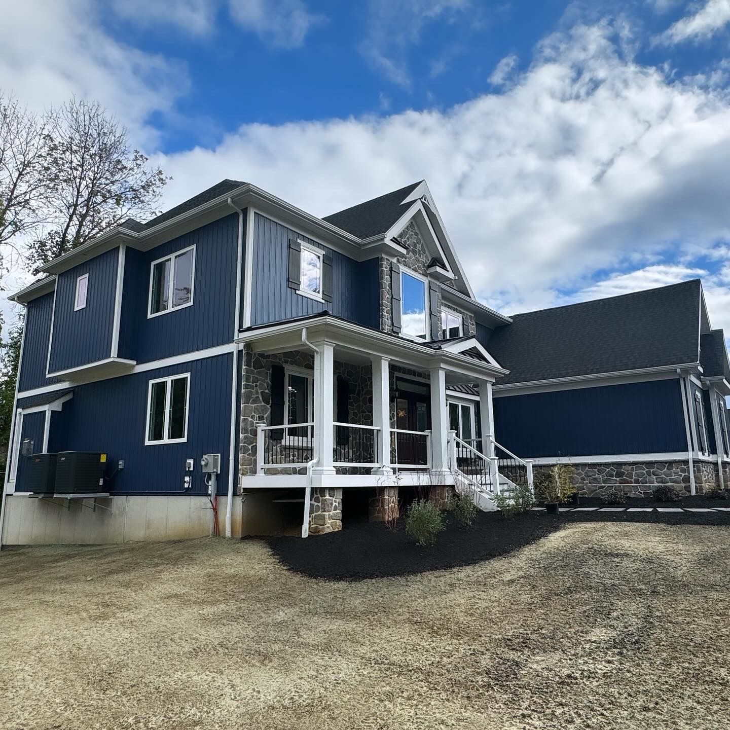 A large blue and white house with a large porch
