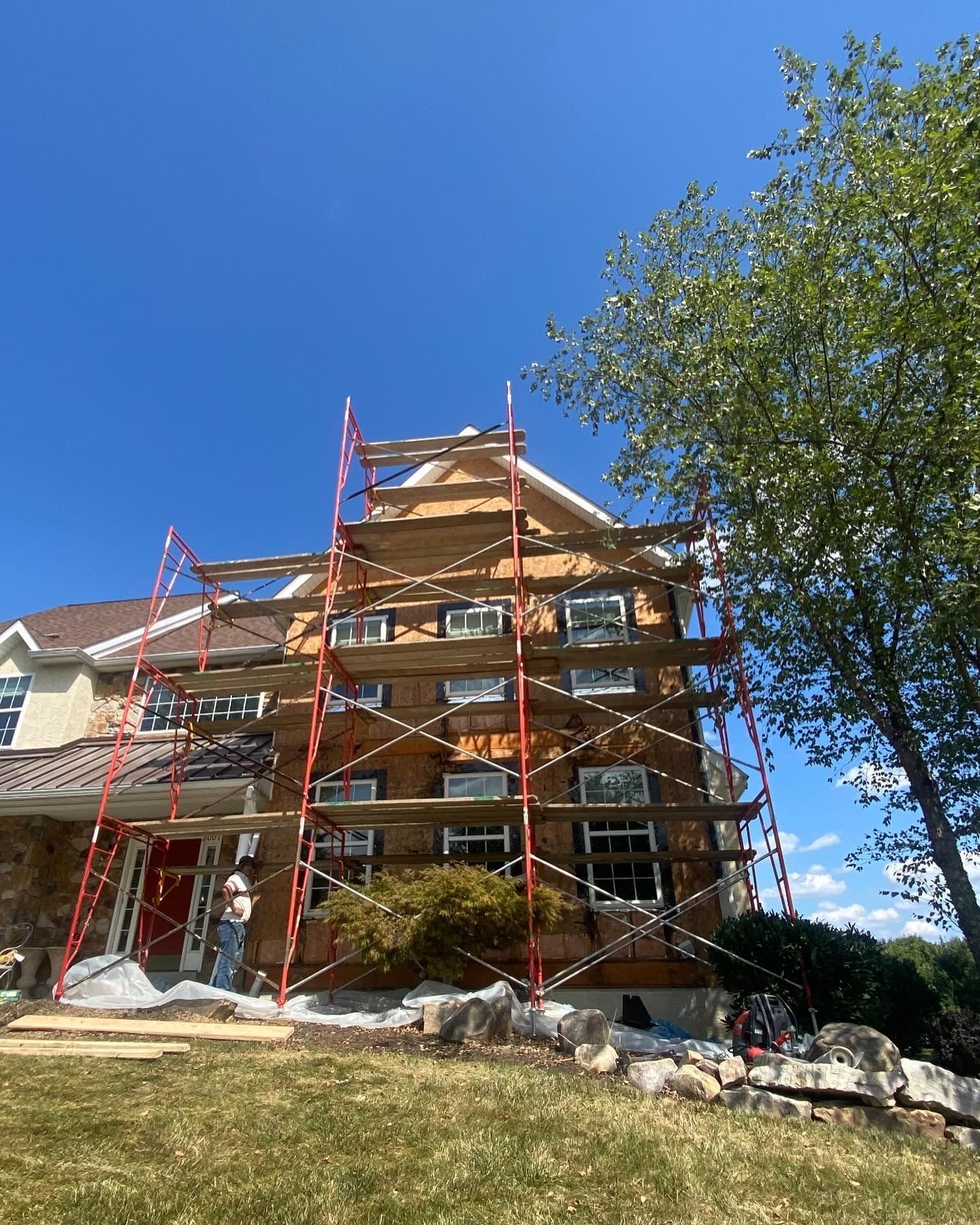 A house is being painted with scaffolding in front of it.