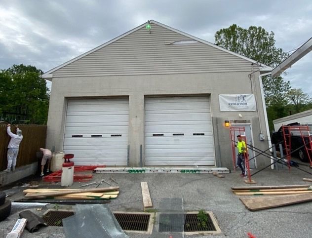 A building with two garage doors is being remodeled.