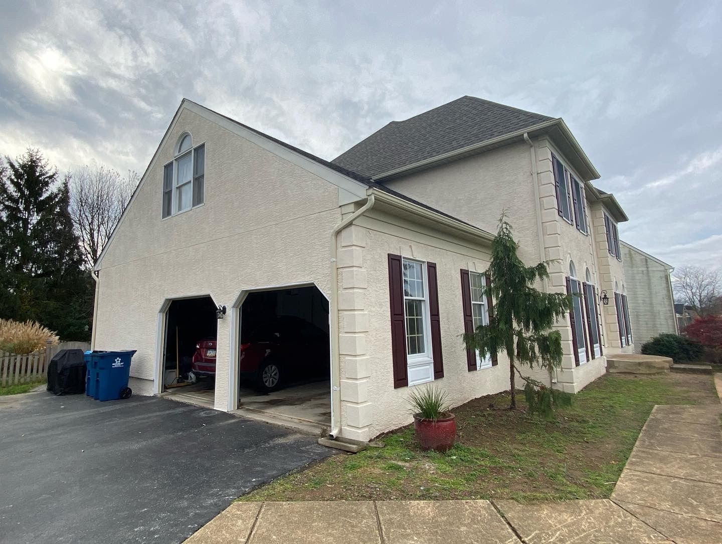 A large white house with a car parked in the garage.