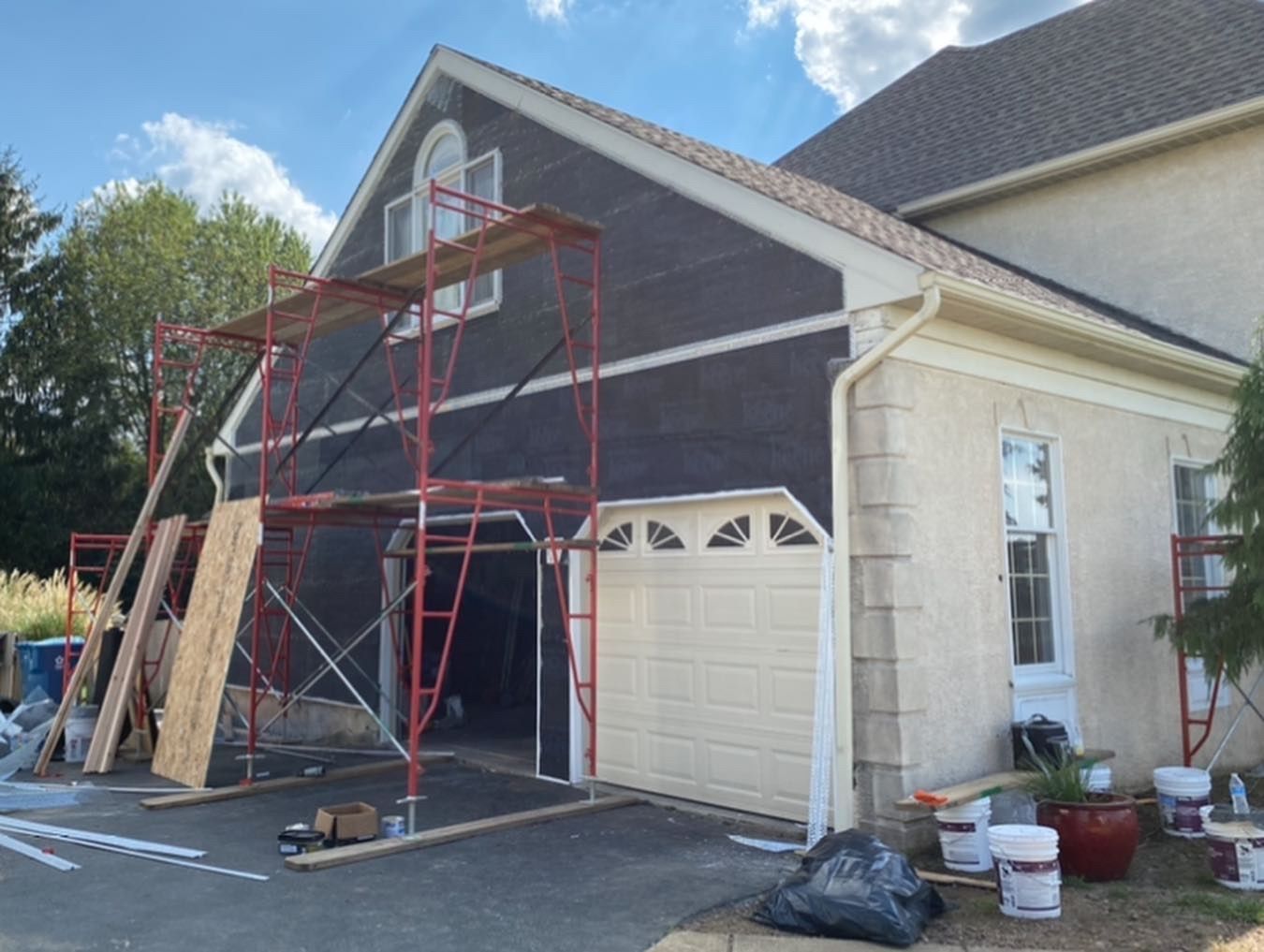 A house is being remodeled with scaffolding around the garage door.
