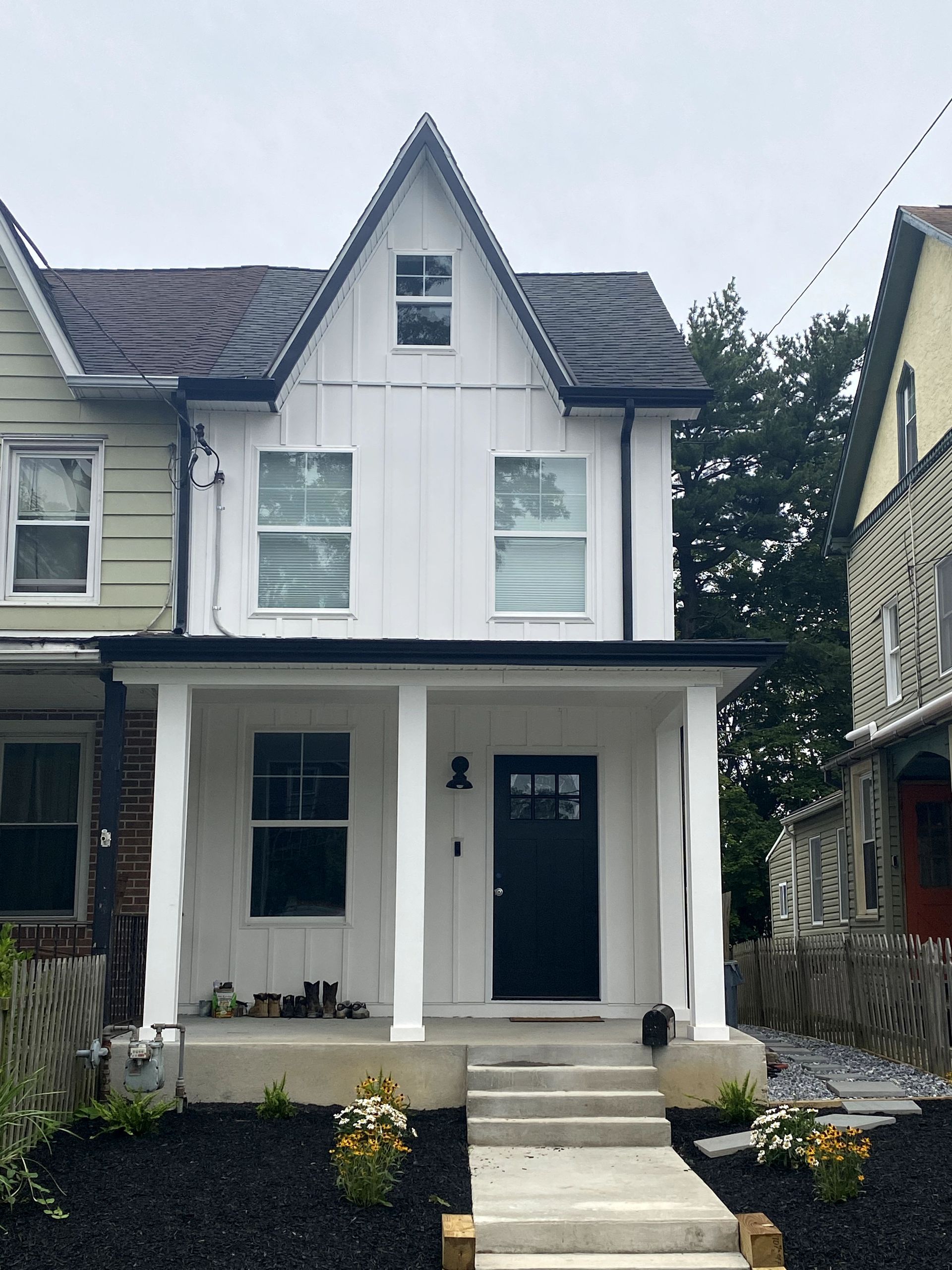 The front of a white house with a black door