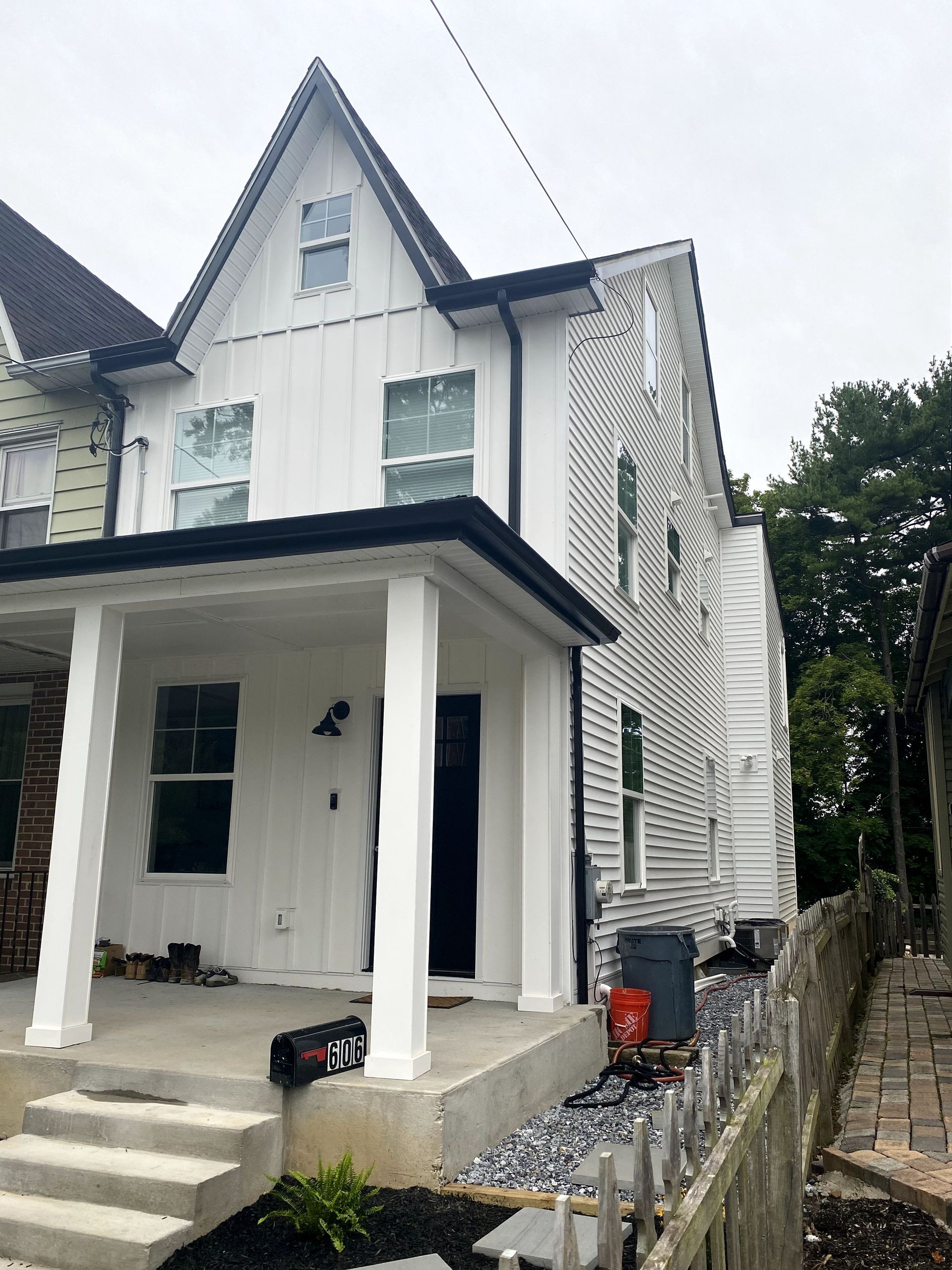 A white house with a black roof and a porch