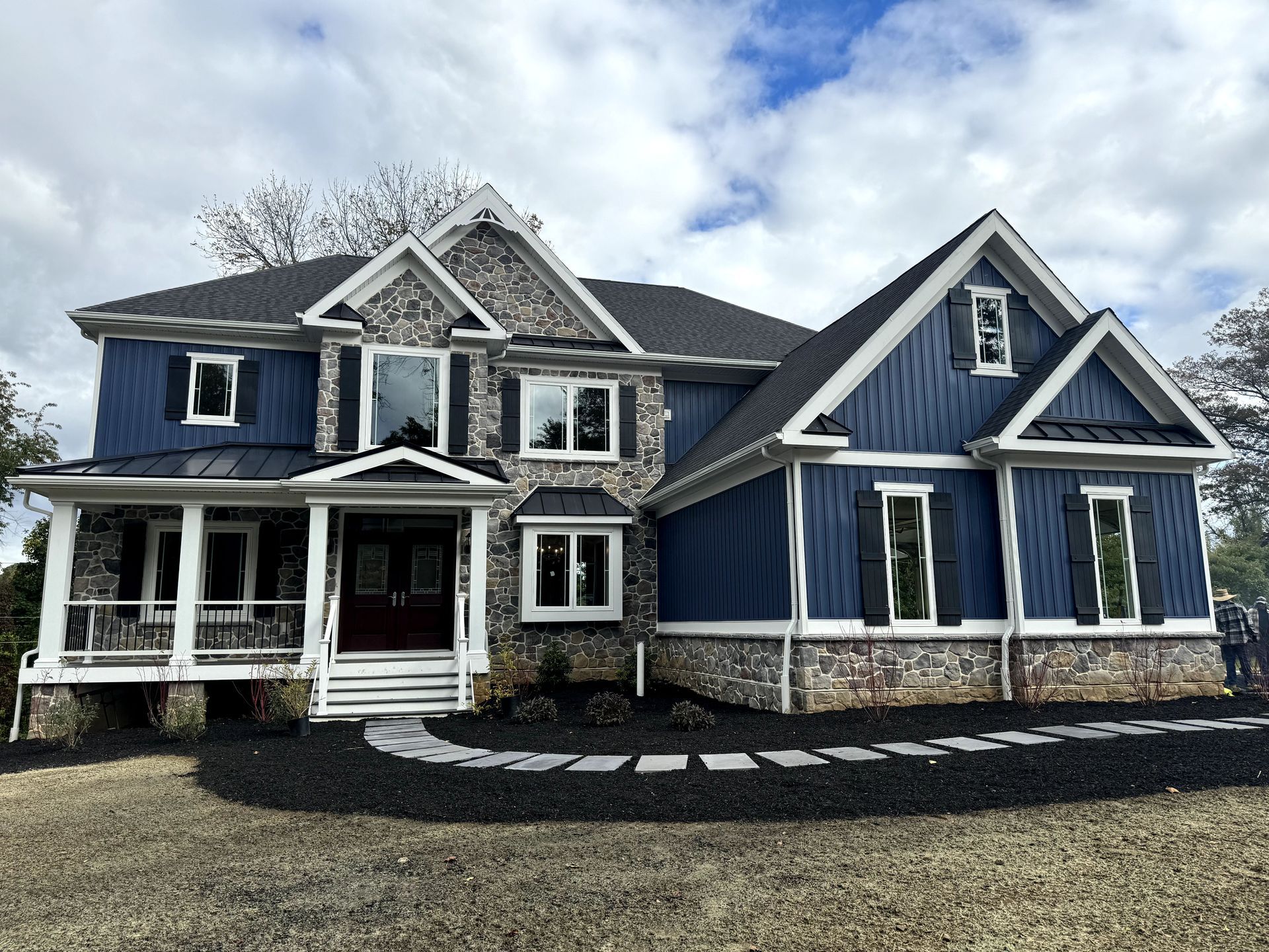 A large blue house with white trim and a porch