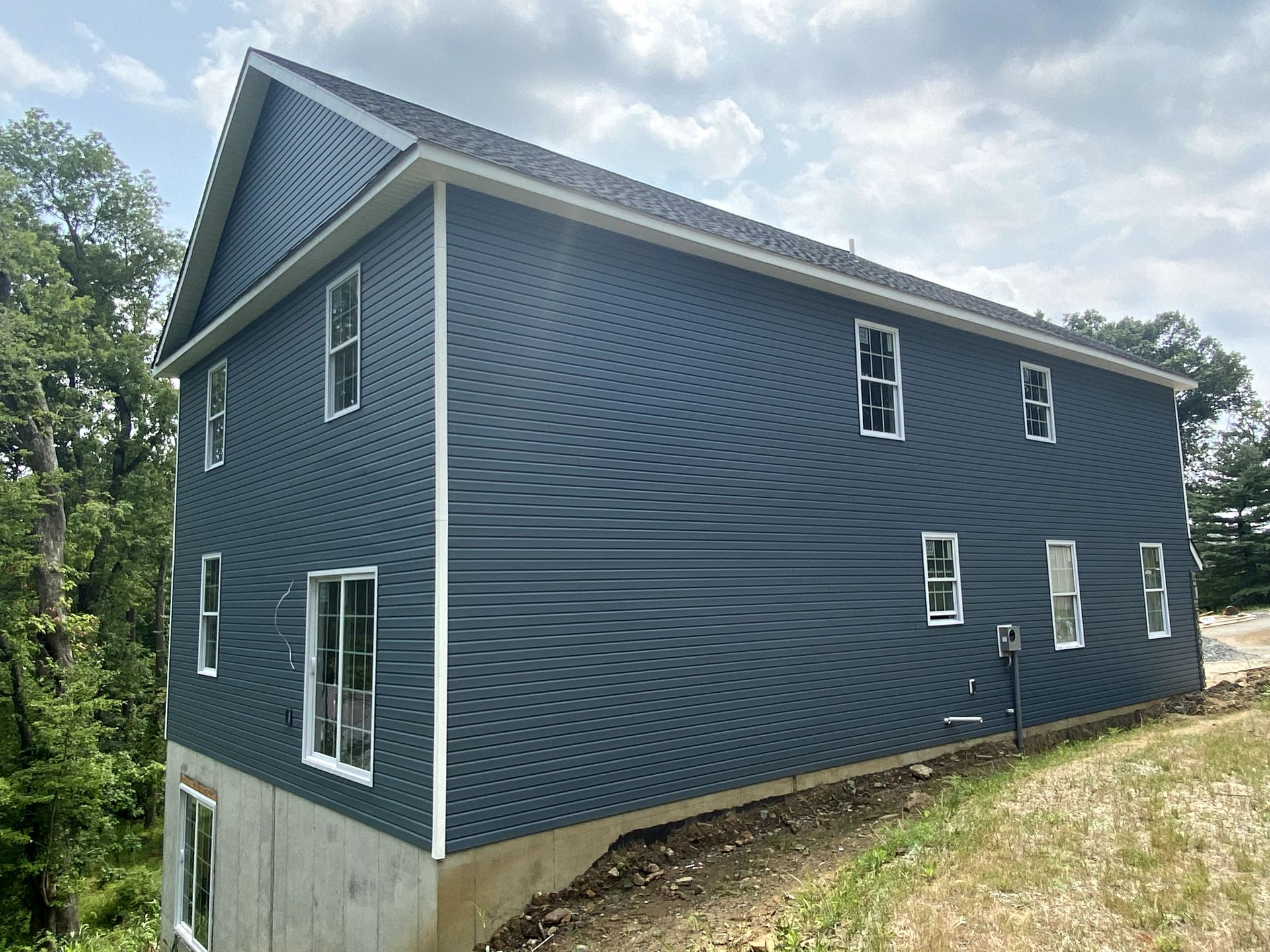 A large blue house is sitting on top of a hill.
