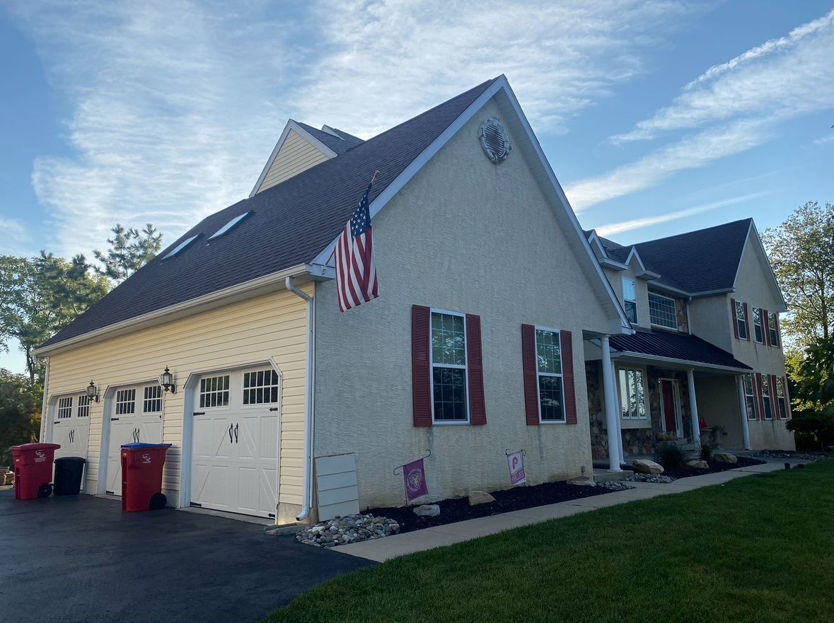 A large house with two garages and an american flag on the front.