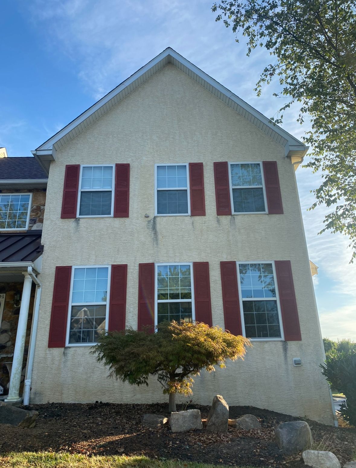 A large house with red shutters on the windows