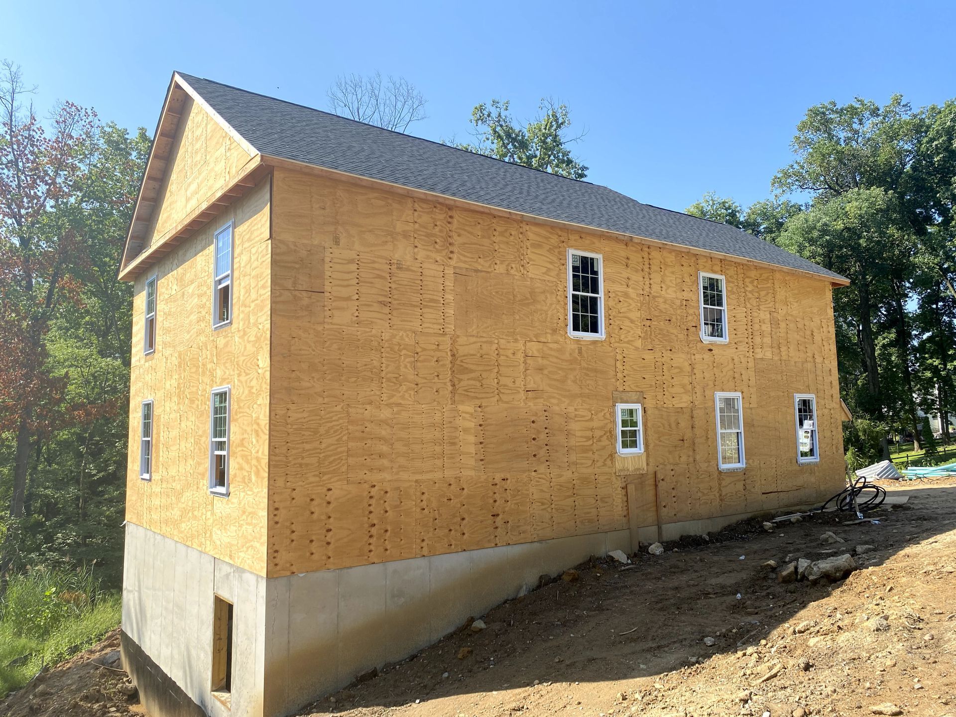 A house is being built on top of a dirt hill.