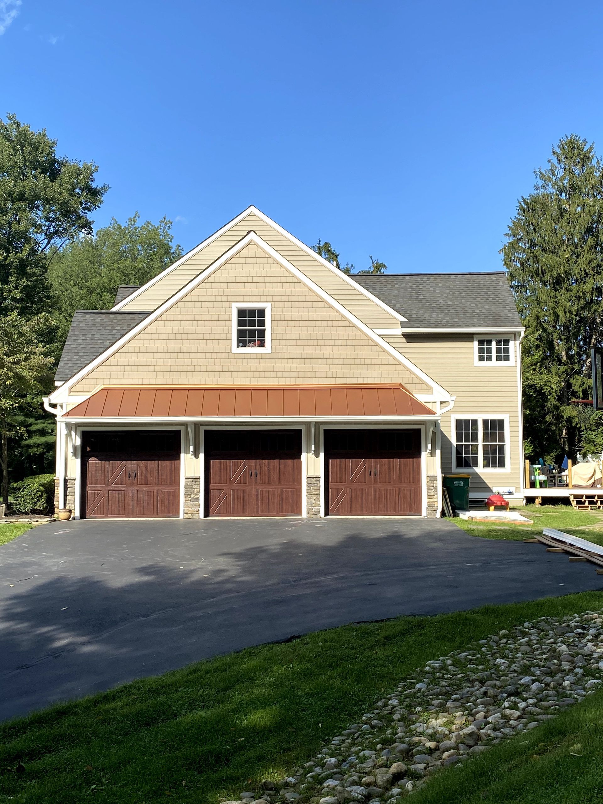 A large house with three garage doors and a driveway.