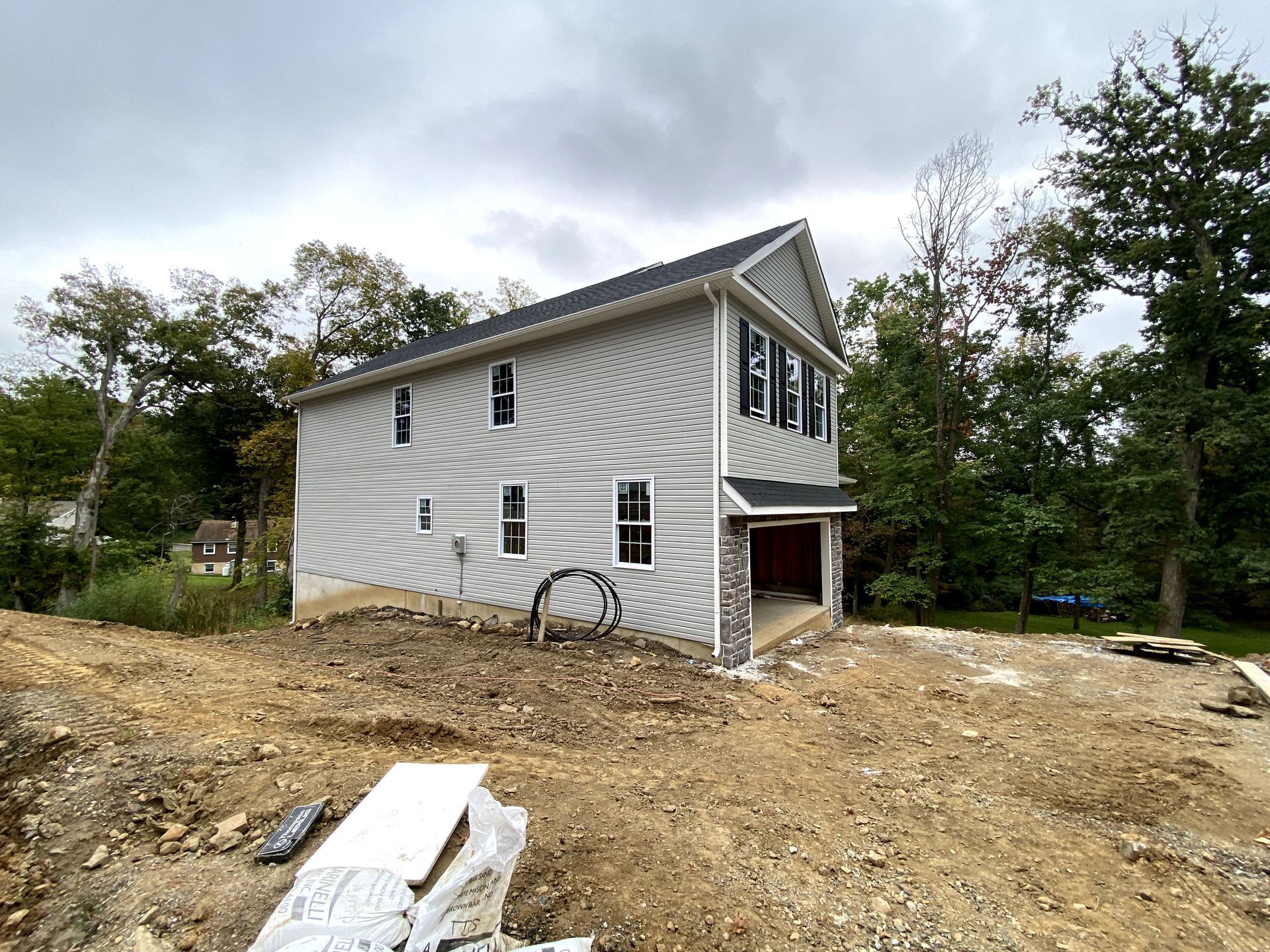 A white house is sitting on top of a dirt hill.