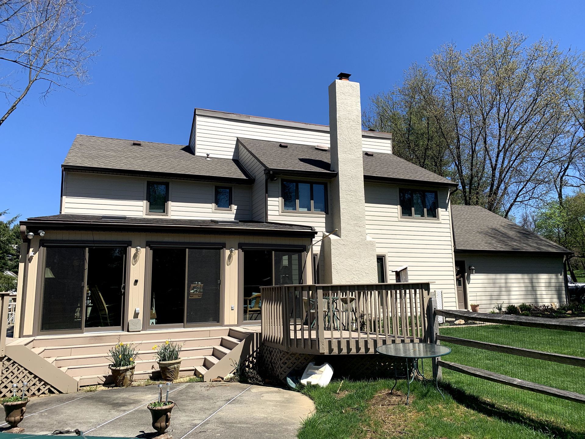 The back of a house with a deck and a chimney