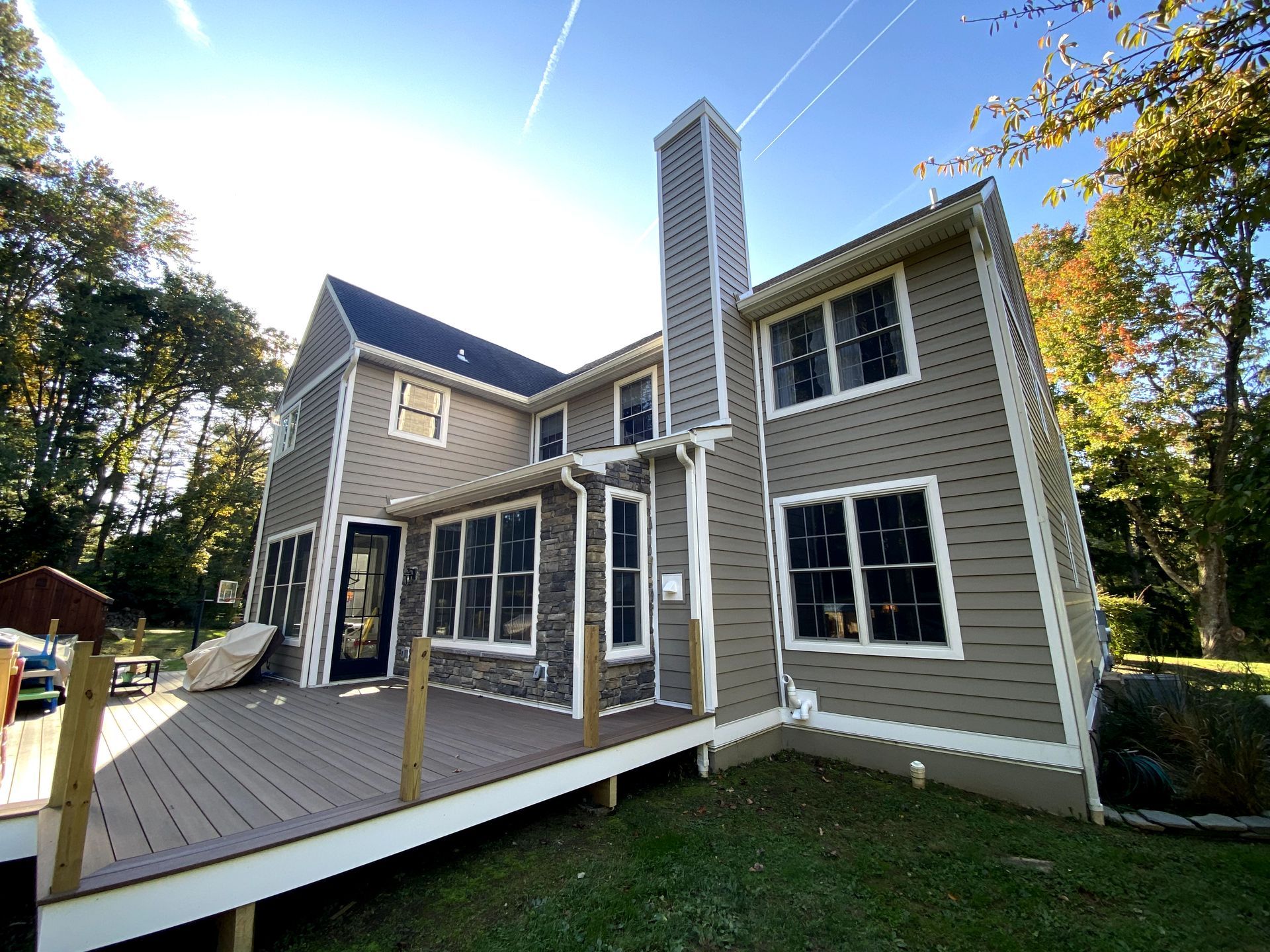 A large house with a large deck and a large chimney