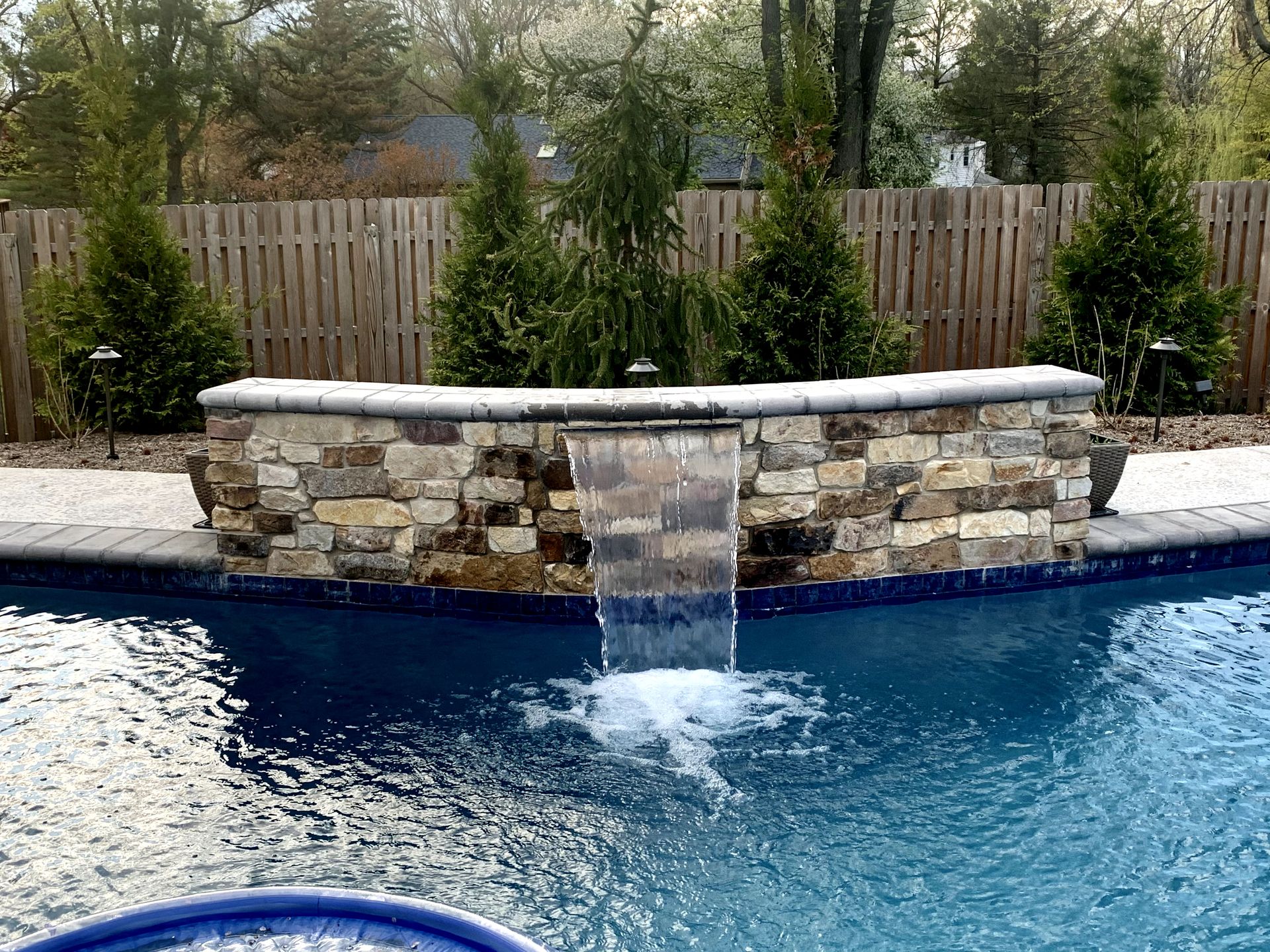 There is a waterfall in the middle of the pool.