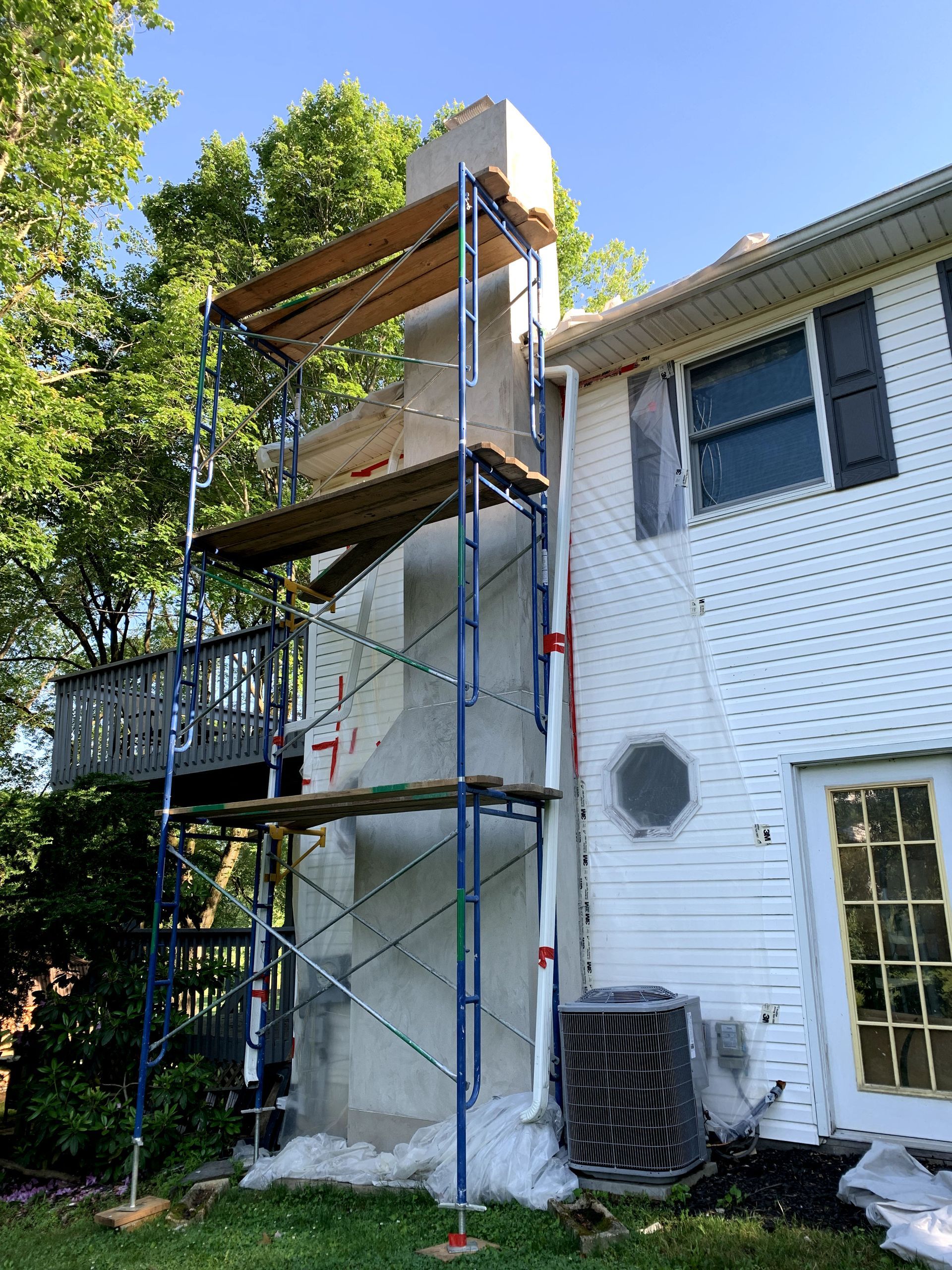 A white house with scaffolding on the side of it.