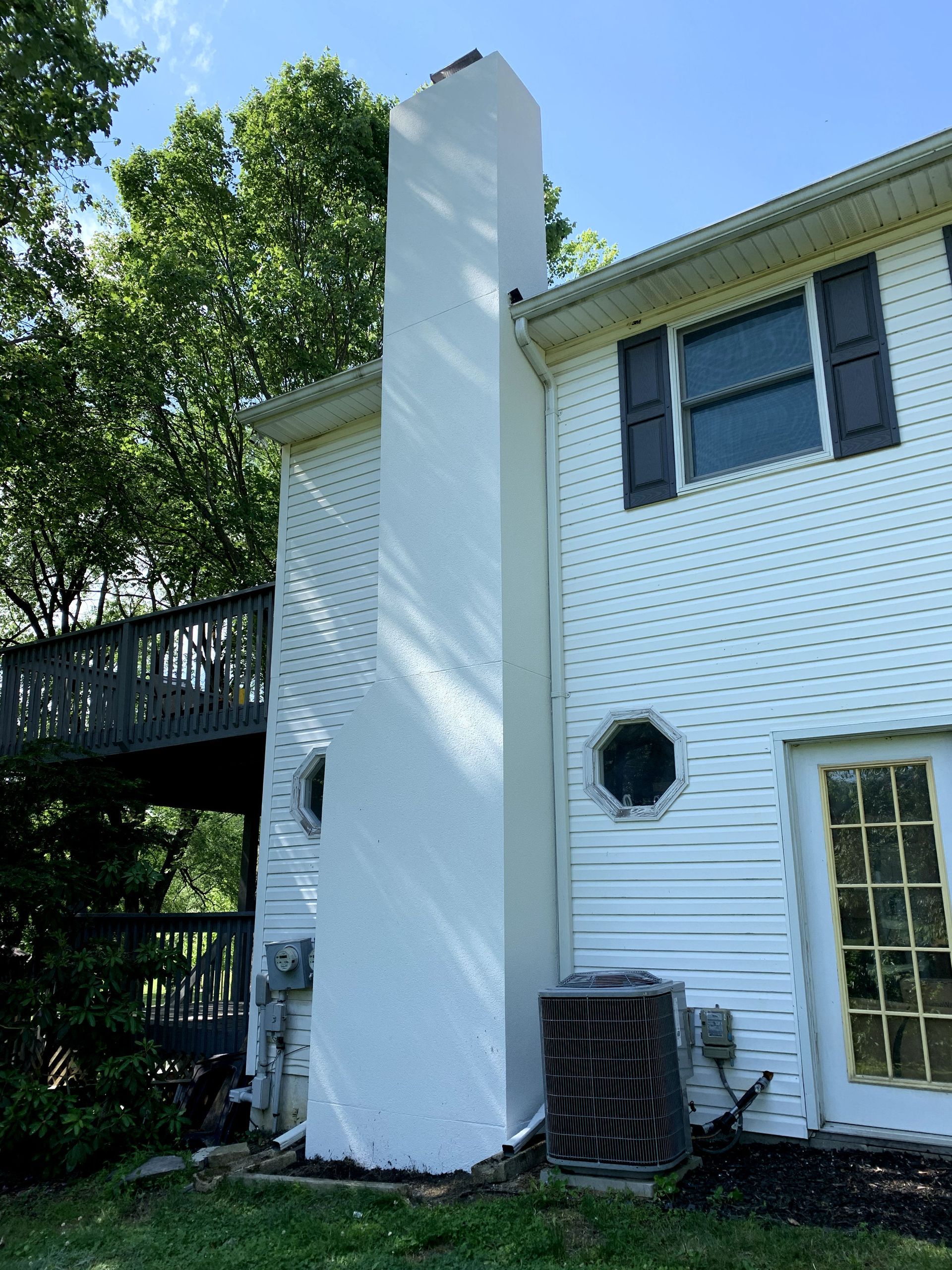 A white house with a chimney on the side of it
