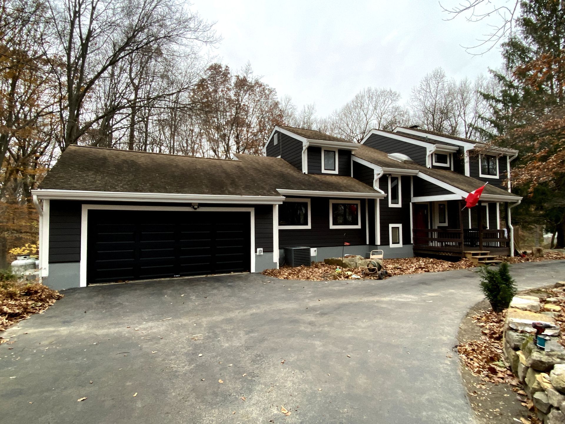 A black and white house with a black garage door