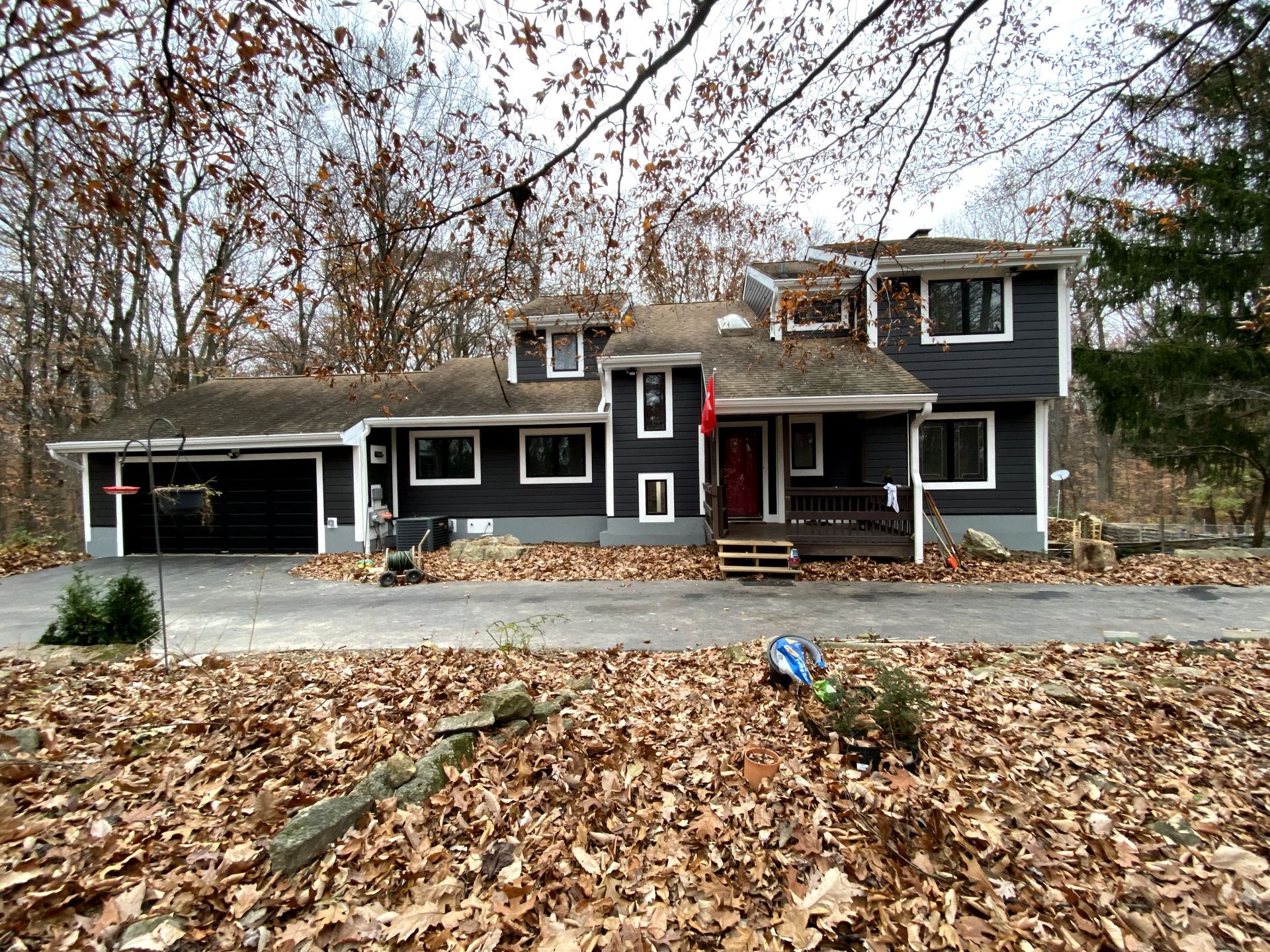 A house with a lot of leaves on the ground in front of it