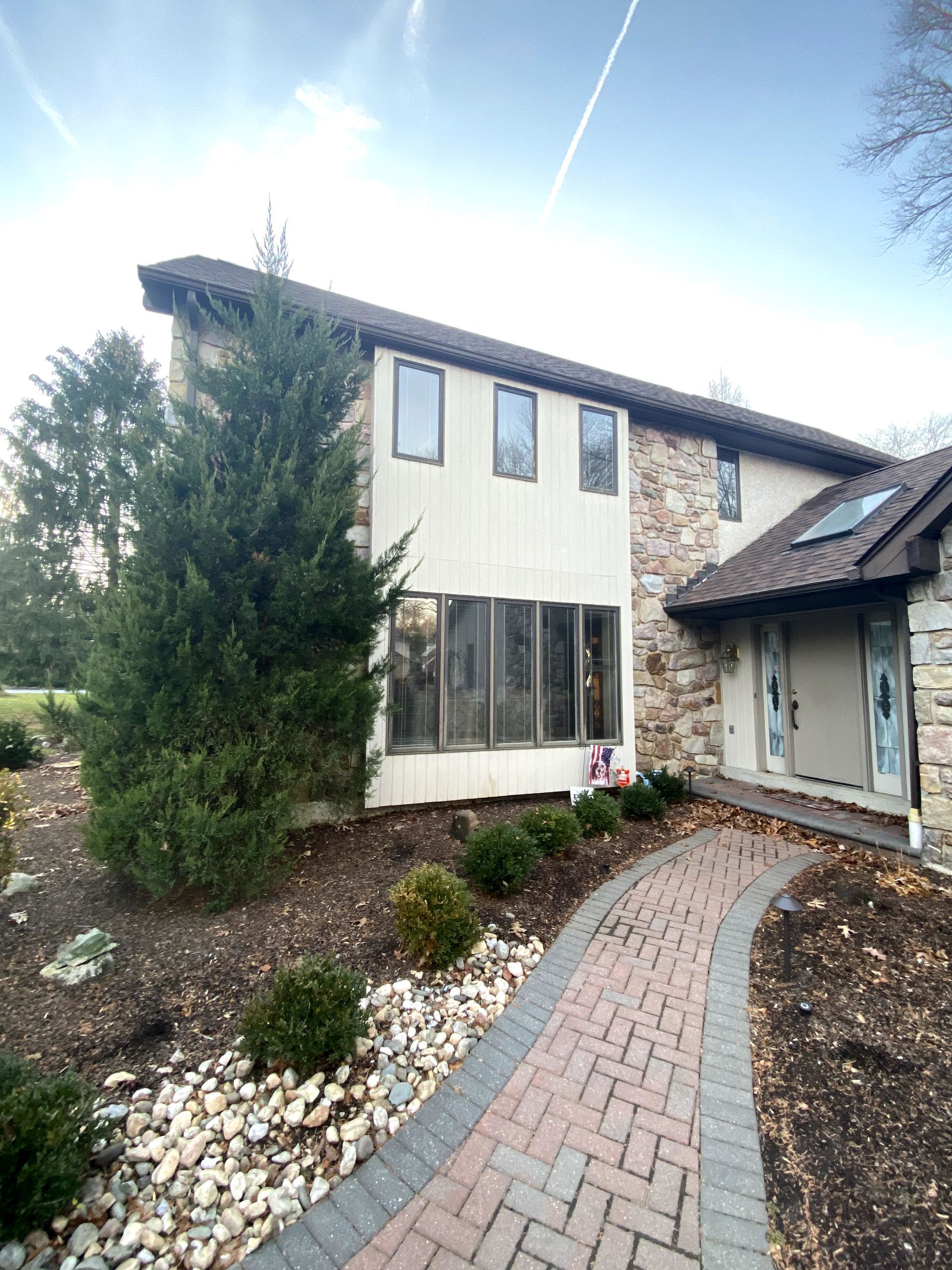 A large house with a brick walkway leading to it.