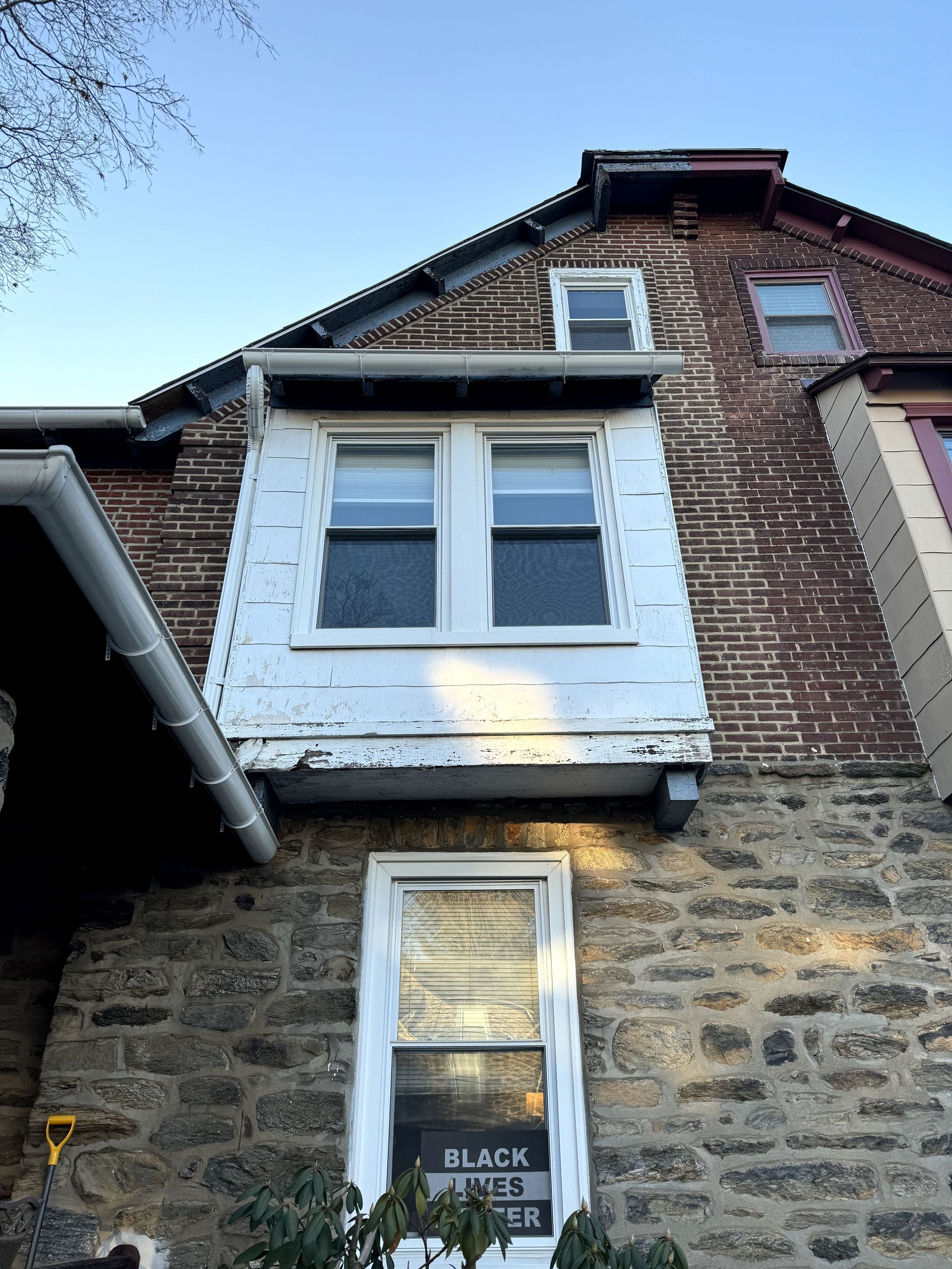 The front of a brick house with a white window