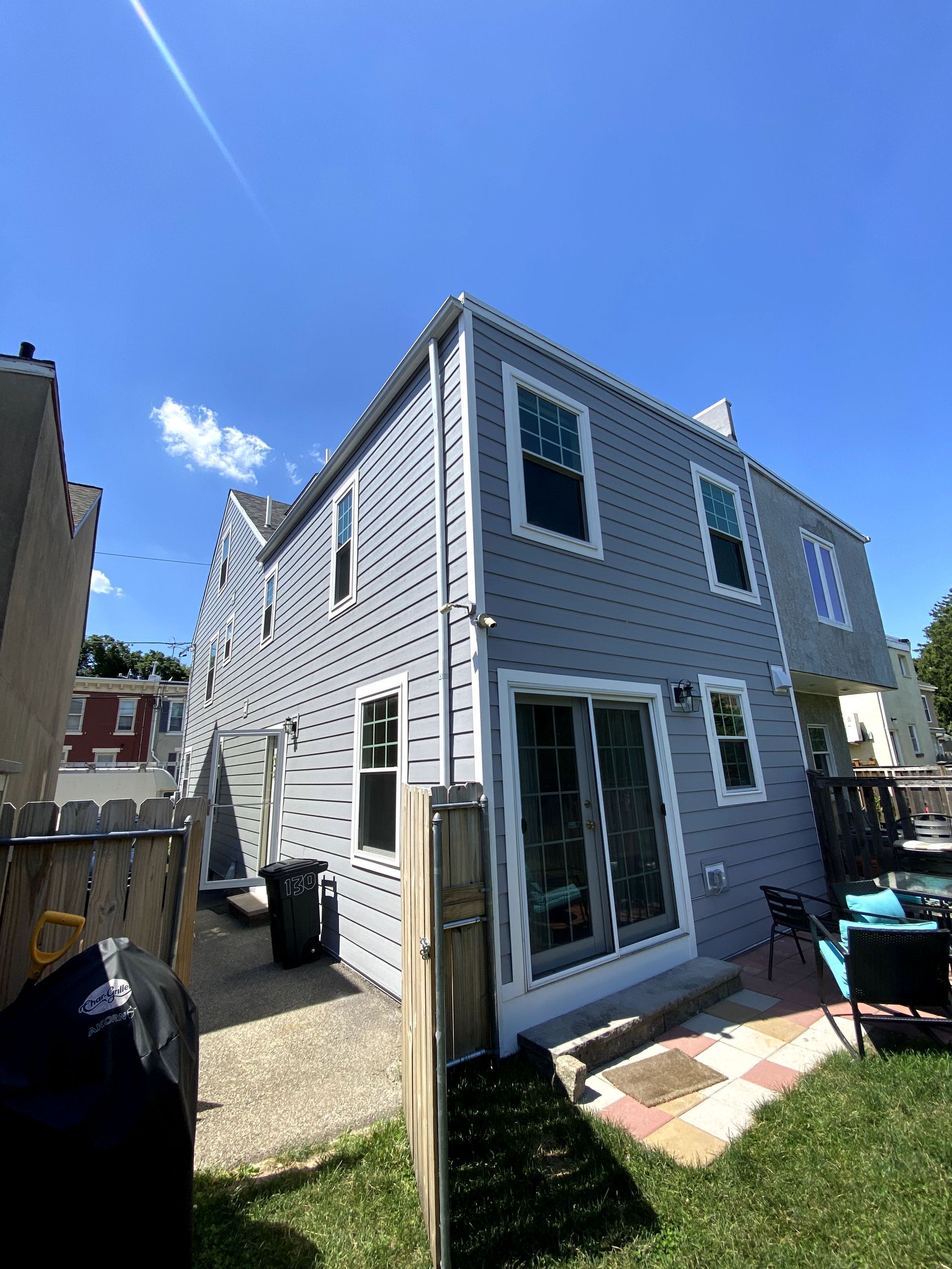 The back of a house with a lot of windows and sliding glass doors.