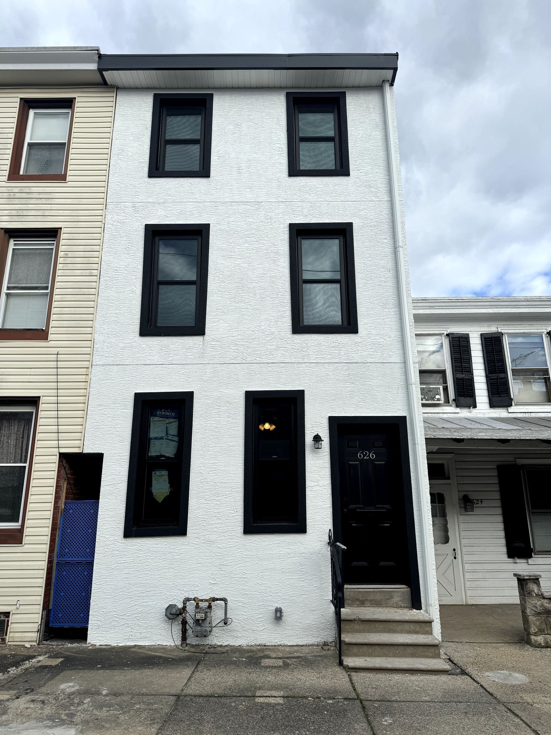 A white building with black windows and stairs