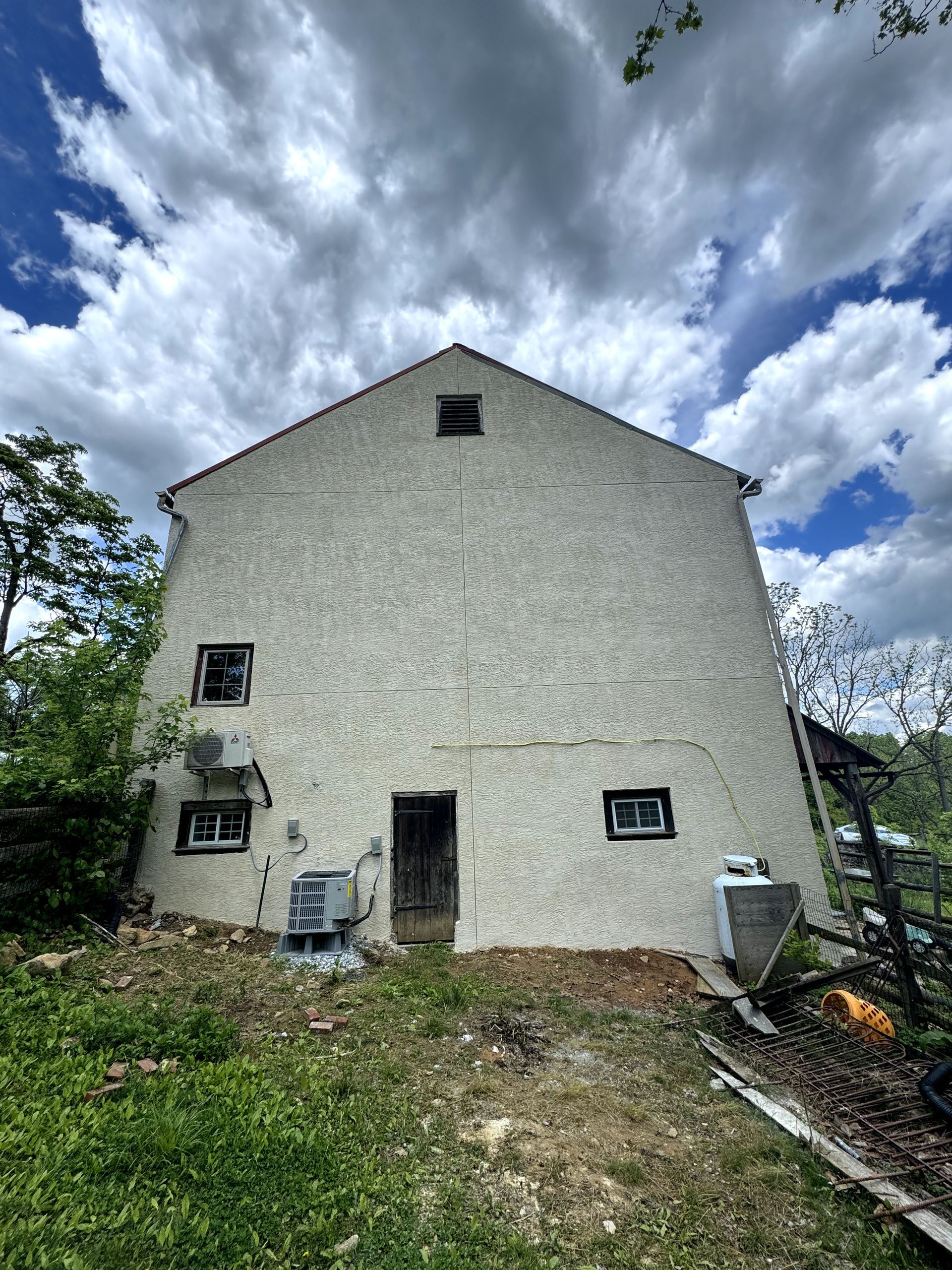 A large white building with a blue sky and clouds in the background.