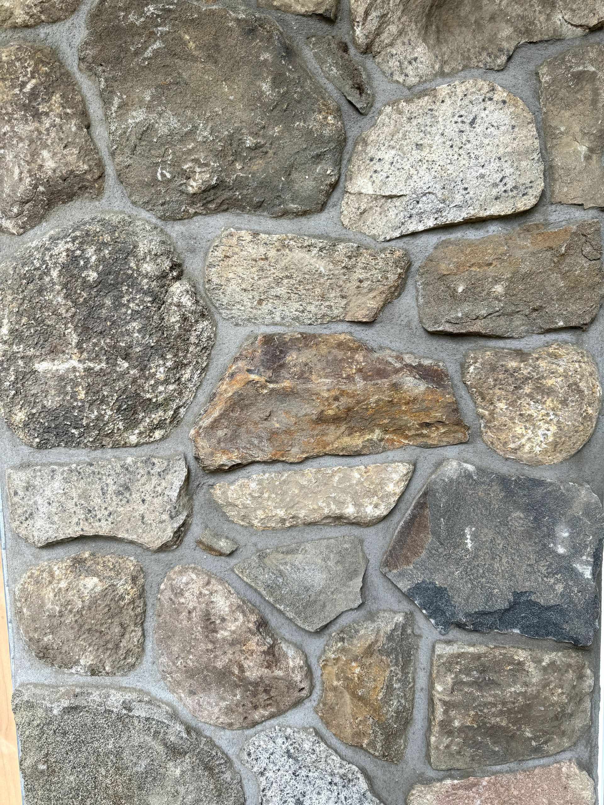 A close up of a stone wall with a lot of rocks.