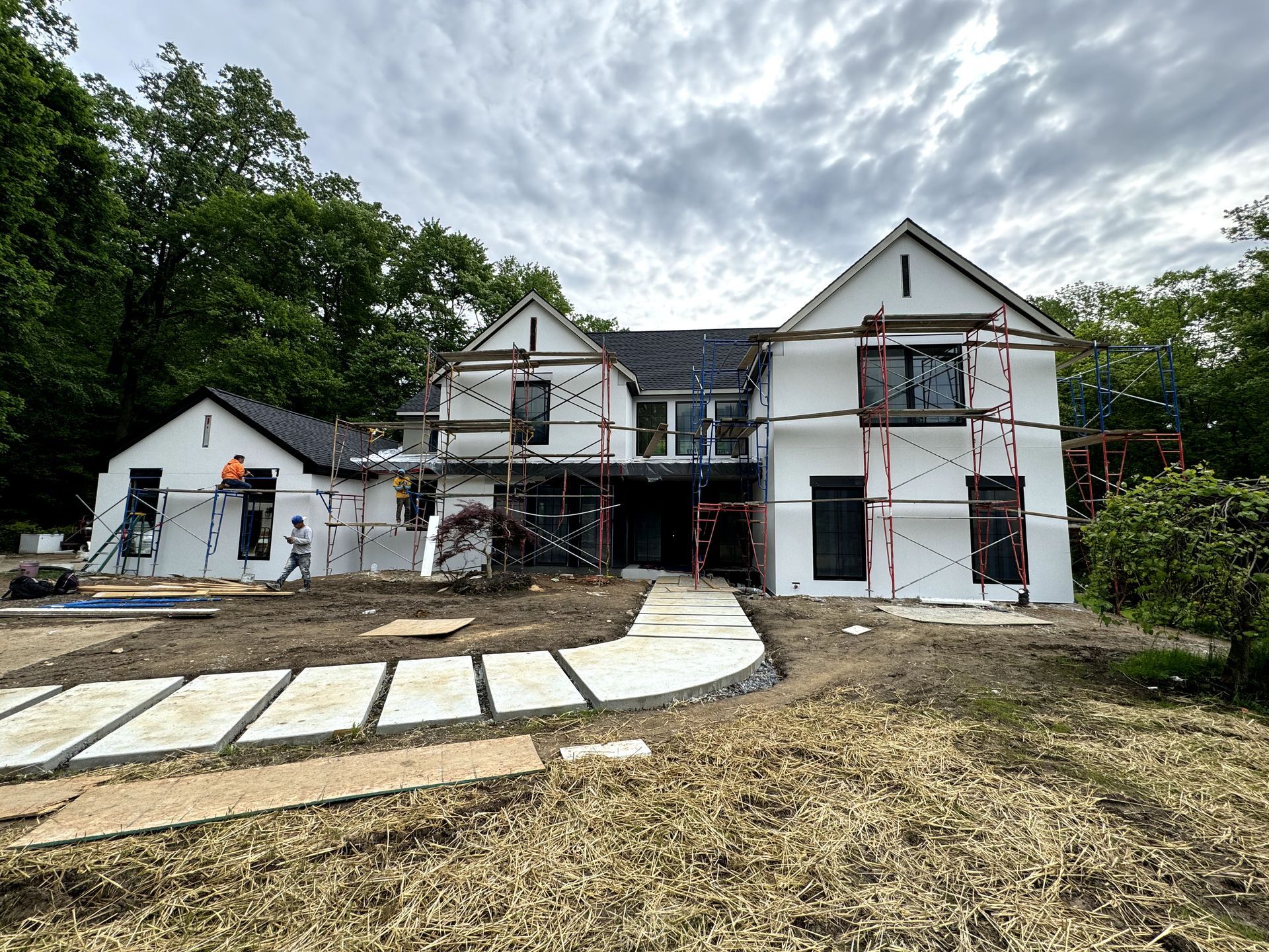 A large white house is being built with scaffolding around it.
